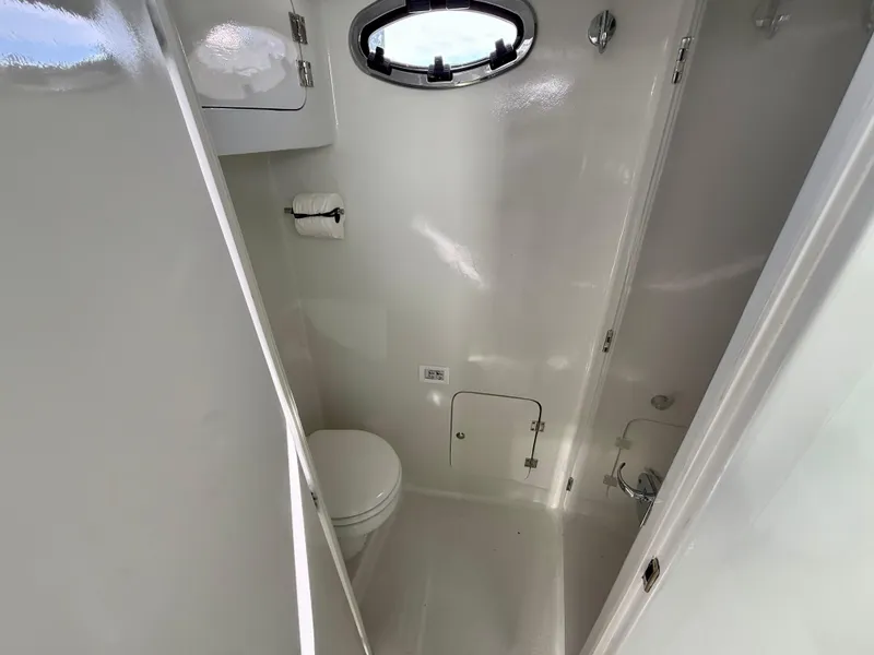 Slide: The Image of 2023 Millennium Marine NuWave 37 boat bathroom with toilet and porthole window. - 49