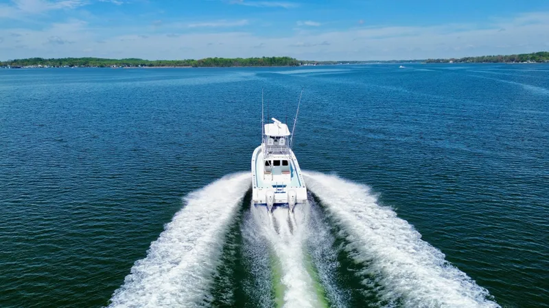 Slide: The Image of 2023 Millennium Marine NuWave 37 cruising on a serene blue lake. - 7