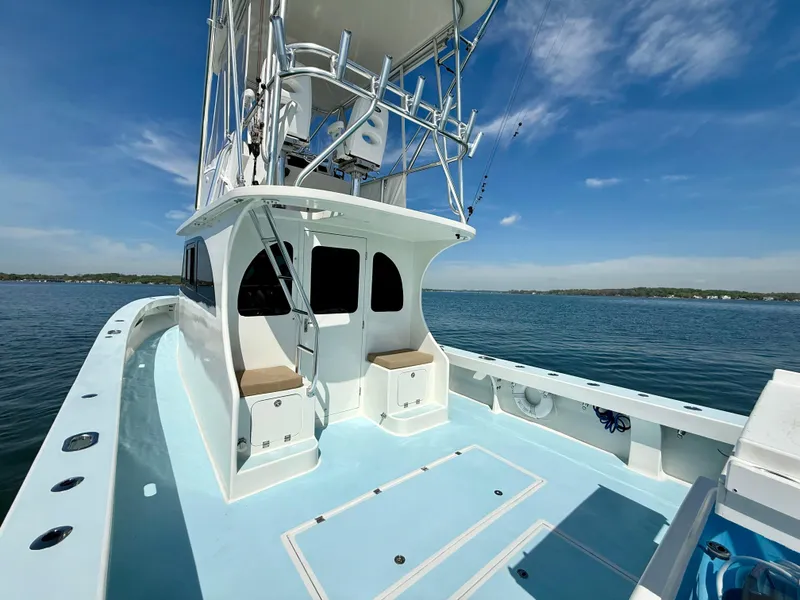 Slide: The Image of 2023 Millennium Marine NuWave 37 boat on calm water under clear blue sky. - 9