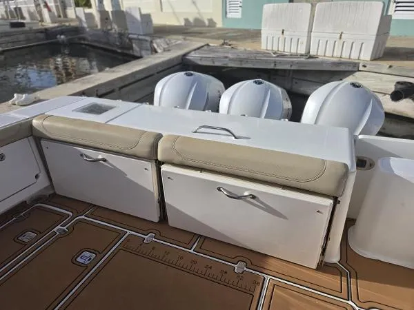 Slide: The Image of 2019 Pursuit OS 385 Offshore boat with storage compartments and triple outboard engines. - 11