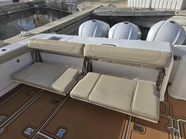 Slide: The Image of 2019 Pursuit OS 385 Offshore boat with foldable beige seats and triple outboard engines. - 12