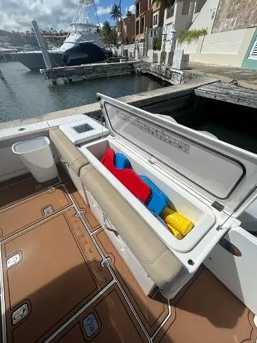 Slide: The Image of 2019 Pursuit OS 385 Offshore boat with open storage compartment at marina. - 13