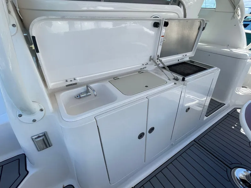 Slide: The Image of 2019 Pursuit OS 385 Offshore boat kitchenette with sink and grill. - 16
