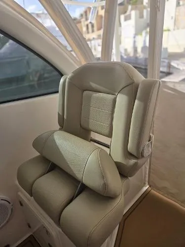 Slide: The Image of 2019 Pursuit OS 385 Offshore boat seat, beige upholstery, interior view. - 19