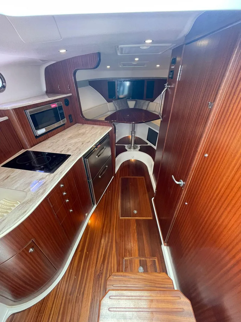 Slide: The Image of 2019 Pursuit OS 385 Offshore yacht interior with modern kitchen and wood finish. - 22