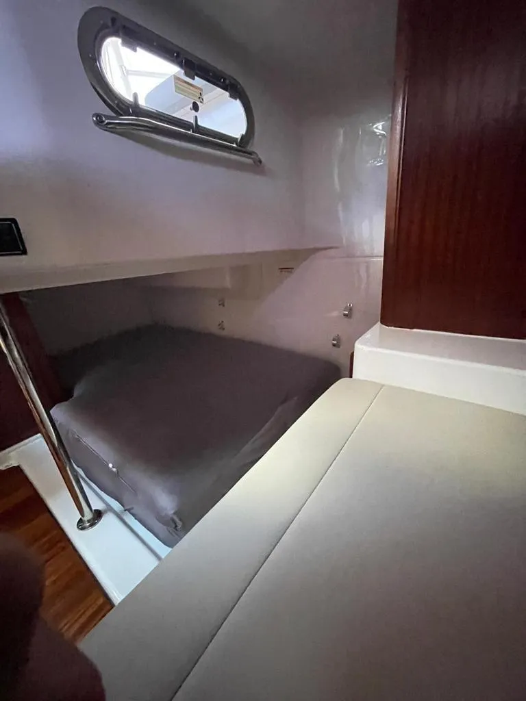 Slide: The Image of 2019 Pursuit OS 385 Offshore cabin interior with bed and window. - 27