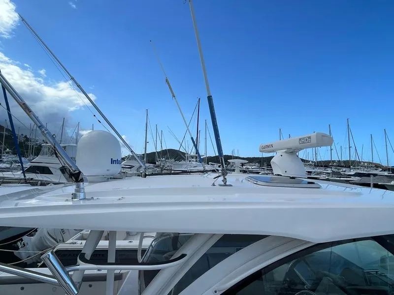 Slide: The Image of 2019 Pursuit OS 385 Offshore boat docked, featuring radar and antennas under a clear blue sky. - 3