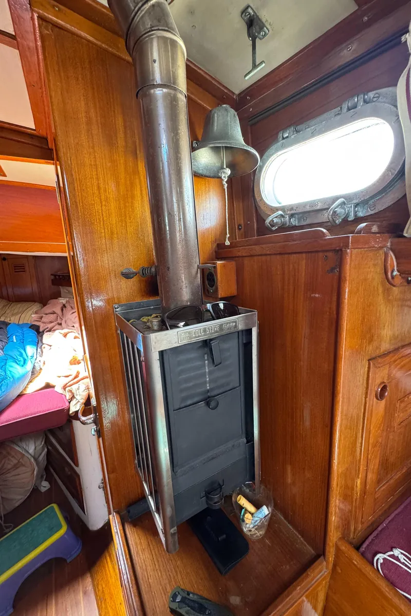 Slide: The Image of 1979 Cheoy Lee Bill Luders Clipper Ketch interior with wood stove and porthole. - 10