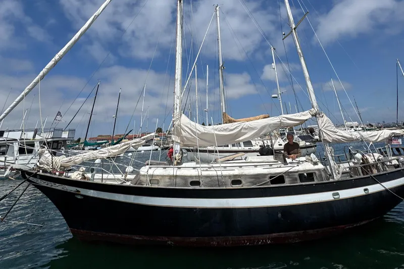 Slide: The Image of 1979 Cheoy Lee Bill Luders Clipper Ketch sailboat docked in a marina under blue skies. - 7