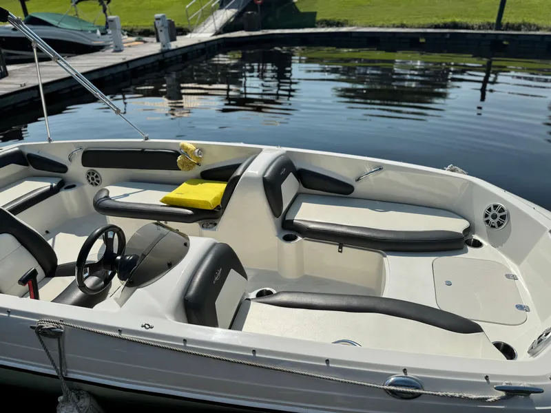 Slide: The Image of 2017 Stingray 182 SC boat interior at dock, featuring sleek seating and steering wheel. - 19