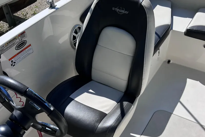 Slide: The Image of 2017 Stingray 182 SC boat interior with black and white captain's seat. - 25