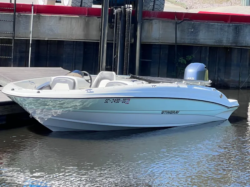 Slide: The Image of 2017 Stingray 182 SC boat docked on calm water, featuring sleek white design. - 7