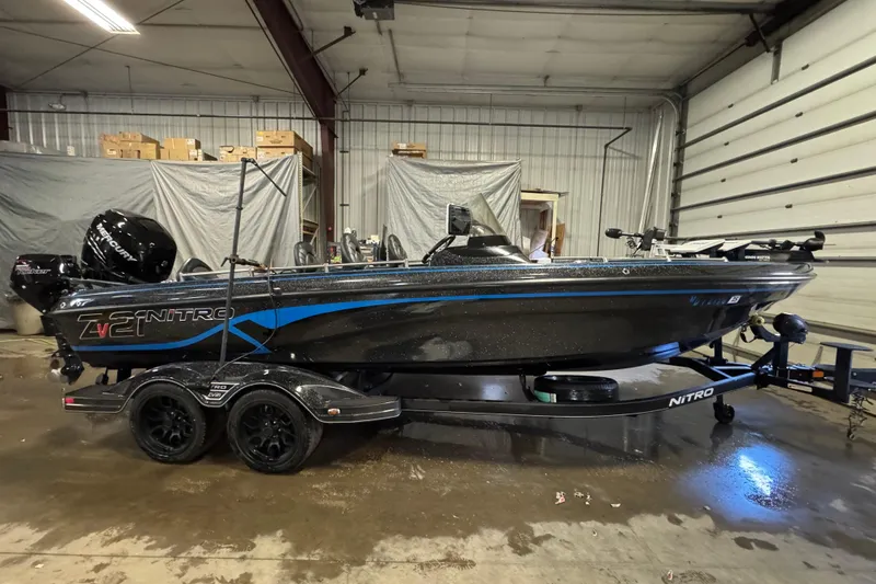 Slide: The Image of 2022 Nitro ZV21 boat in a garage, featuring sleek design and dual-axle trailer. - 0