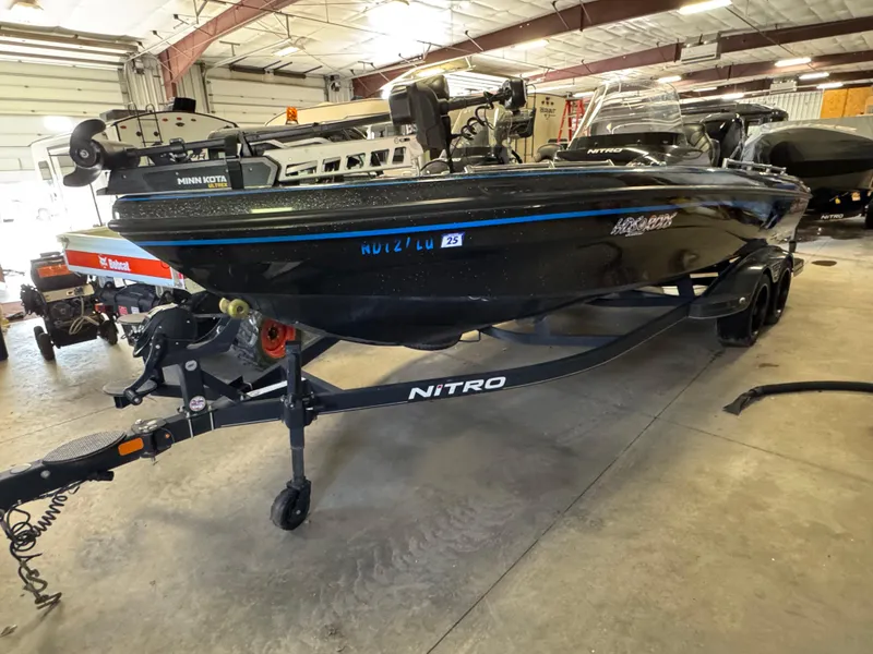 Slide: The Image of 2022 Nitro ZV21 boat in a garage, featuring a Minn Kota motor and dual-axle trailer. - 1
