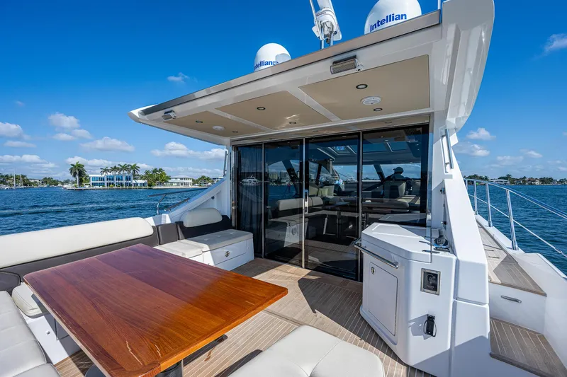 Slide: The Image of Luxurious 2014 Azimut 55S yacht deck with seating and table, overlooking serene waters. - 18