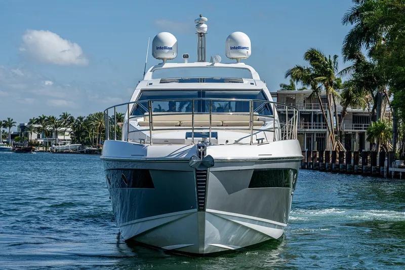 Slide: The Image of 2014 Azimut 55S yacht cruising on a sunny day, surrounded by palm trees and waterfront homes. - 2