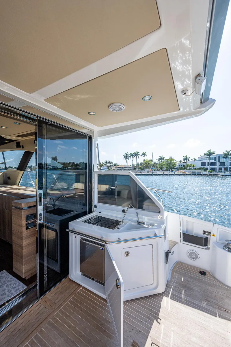 Slide: The Image of 2014 Azimut 55S yacht deck with outdoor kitchen, overlooking serene waterfront. - 25