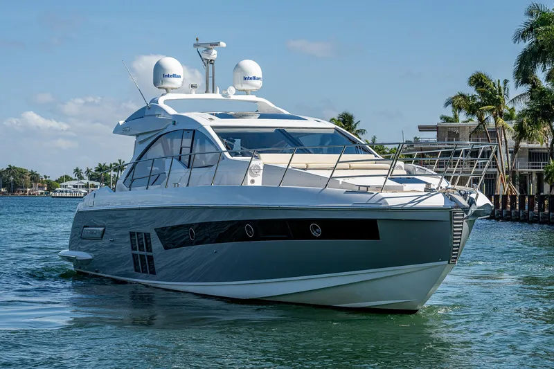 Slide: The Image of 2014 Azimut 55S yacht cruising on a sunny day, surrounded by palm trees and waterfront homes. - 3