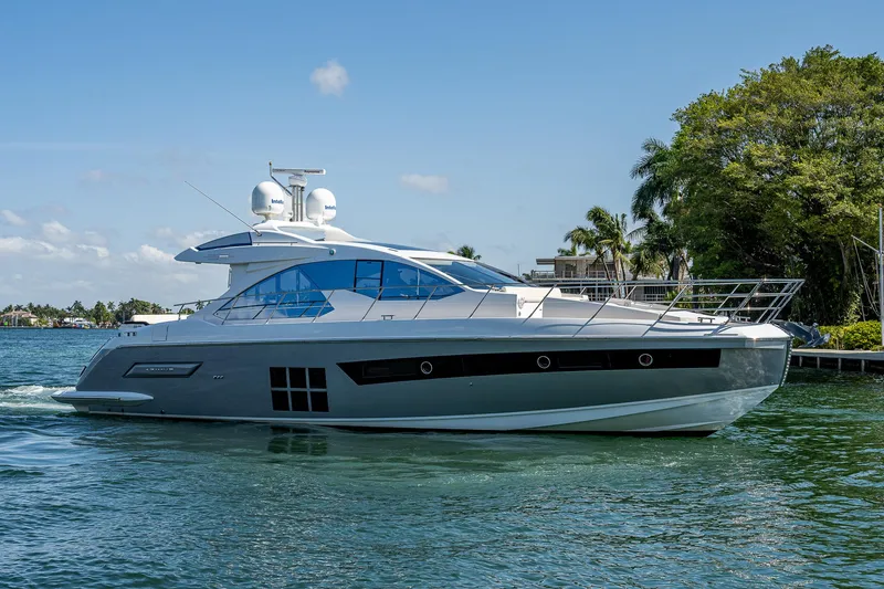 Slide: The Image of 2014 Azimut 55S yacht cruising on a sunny day, surrounded by lush greenery. - 4