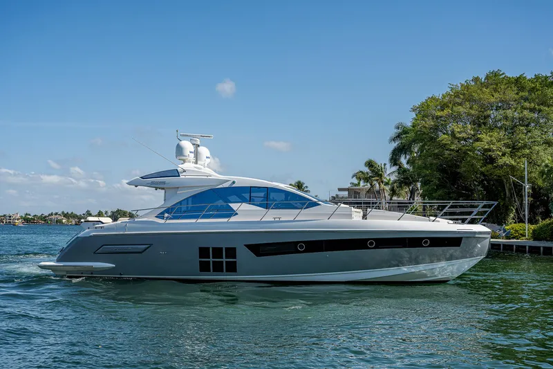 Slide: The Image of 2014 Azimut 55S yacht cruising on a sunny day, surrounded by lush greenery. - 5