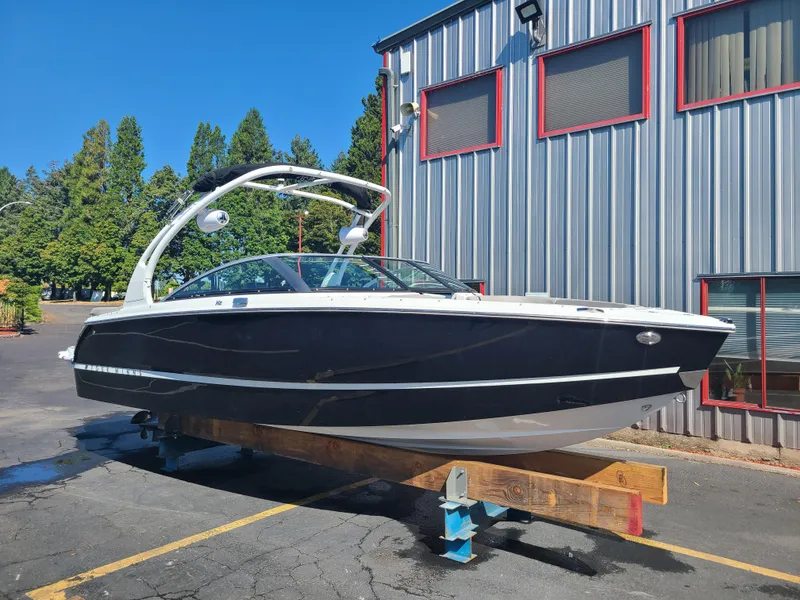 Slide: The Image of 2023 Four Winns H2 boat on display outside a metal building. - 1