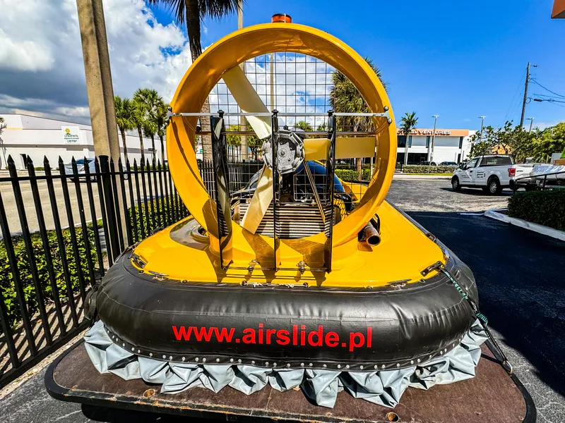 Slide: The Image of 2024 Airslide A33 airboat with yellow hull and visible propeller, parked outdoors. - 10