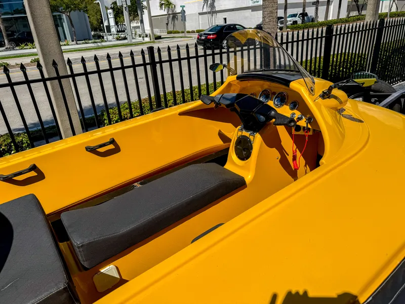 Slide: The Image of 2024 Airboat Airslide A33, yellow interior, sleek design, parked near a black fence. - 5