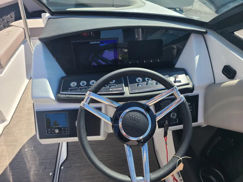 Slide: The Image of 2023 Four Winns H2 boat dashboard with steering wheel and control panel. - 10