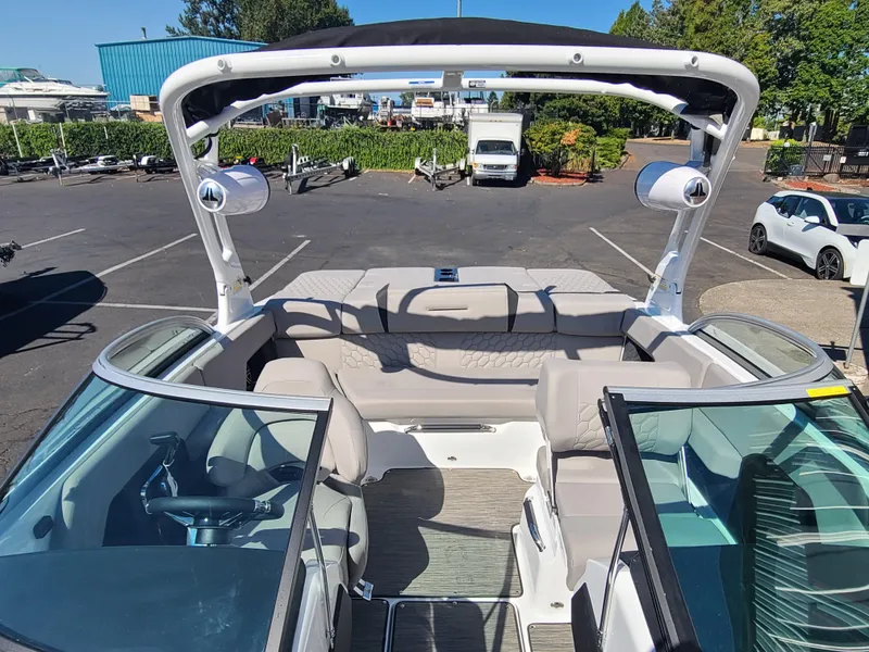 Slide: The Image of 2023 Four Winns H2 boat interior with seating and speakers in a parking lot. - 12