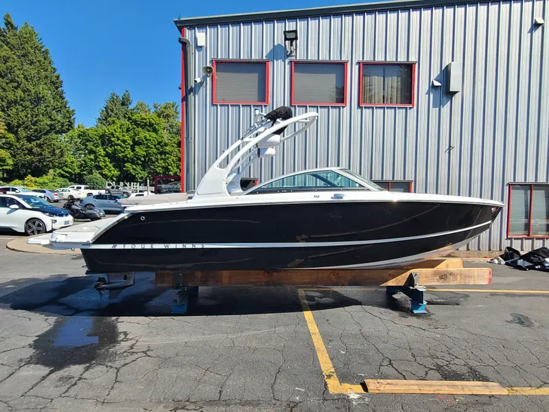 Slide: The Image of 2023 Four Winns H2 boat displayed outdoors on a stand, near a building. - 3