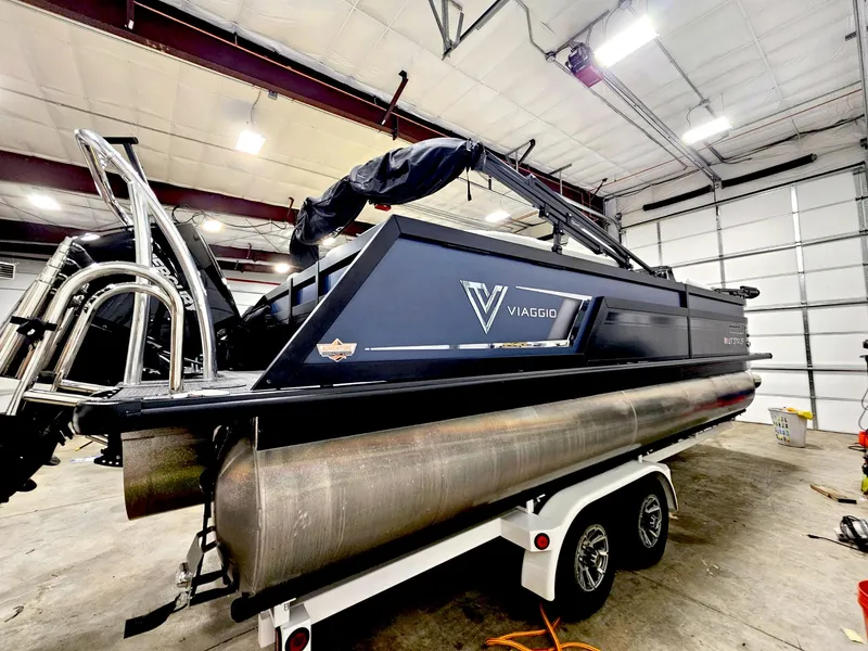Slide: The Image of 2023 Viaggio Diamante U pontoon boat on trailer in a spacious indoor garage. - 1