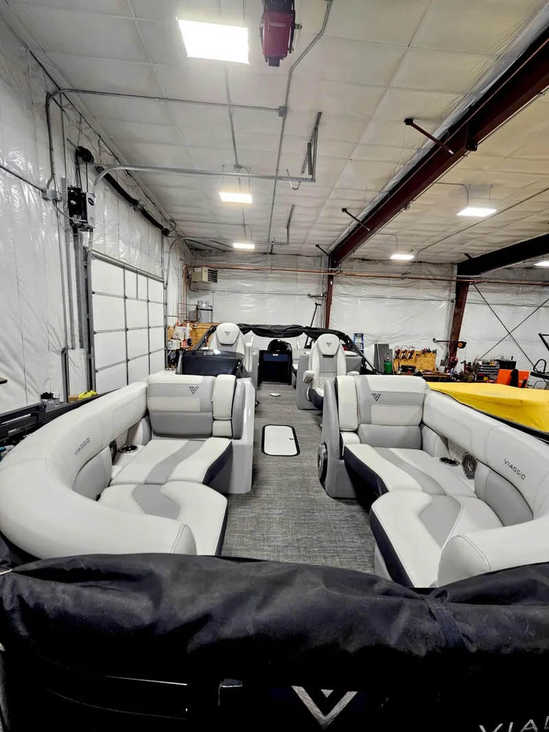 Slide: The Image of 2023 Viaggio Diamante U pontoon boat with luxurious seating in a spacious indoor setting. - 7