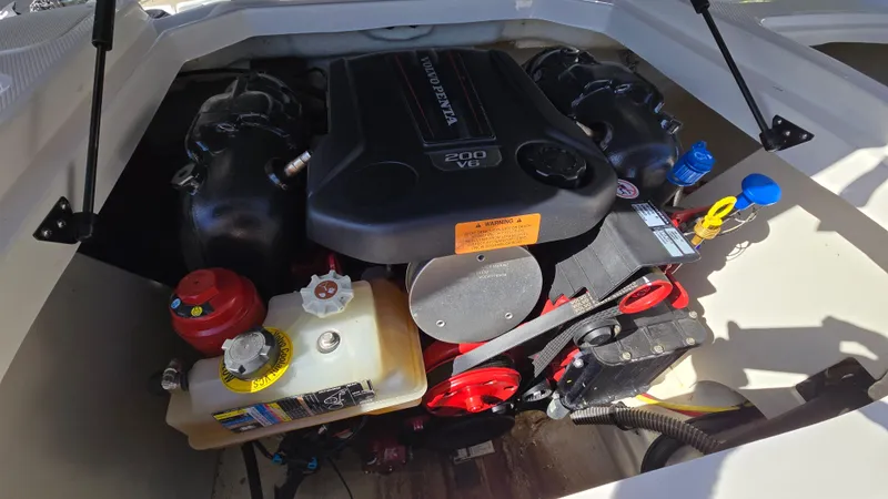 Slide: The Image of 2019 Chaparral 21 H2O Sport engine compartment with visible components and labels. - 12