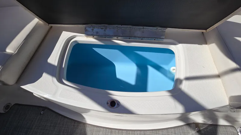 Slide: The Image of 2019 Chaparral 21 H2O Sport boat interior with open storage compartment. - 17