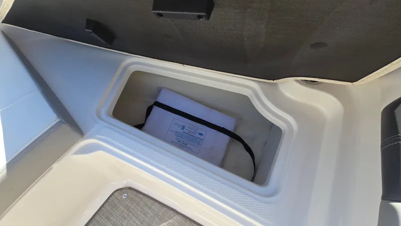 Slide: The Image of 2019 Chaparral 21 H2O Sport storage compartment with manual inside. - 26