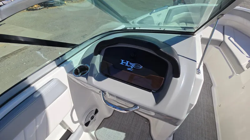 Slide: The Image of 2019 Chaparral 21 H2O Sport boat dashboard with H2O logo and cup holder. - 31