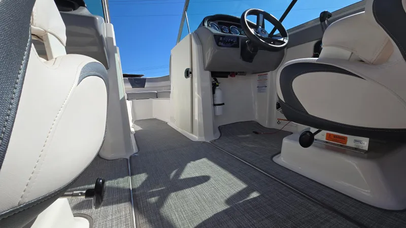 Slide: The Image of 2019 Chaparral 21 H2O Sport boat interior with steering wheel and seating. - 38