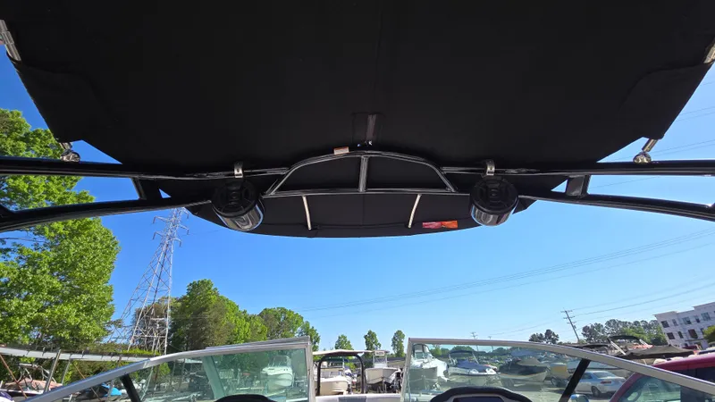 Slide: The Image of 2019 Chaparral 21 H2O Sport boat with black canopy and clear blue sky. - 39