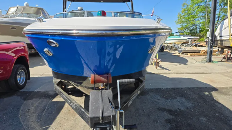 Slide: The Image of 2019 Chaparral 21 H2O Sport boat on trailer, blue hull, parked outdoors. - 7