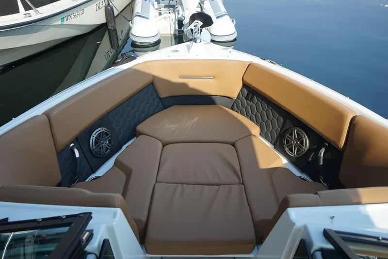 Slide: The Image of 2023 Four Winns H2 Surf boat interior with brown cushioned seating and speakers. - 12