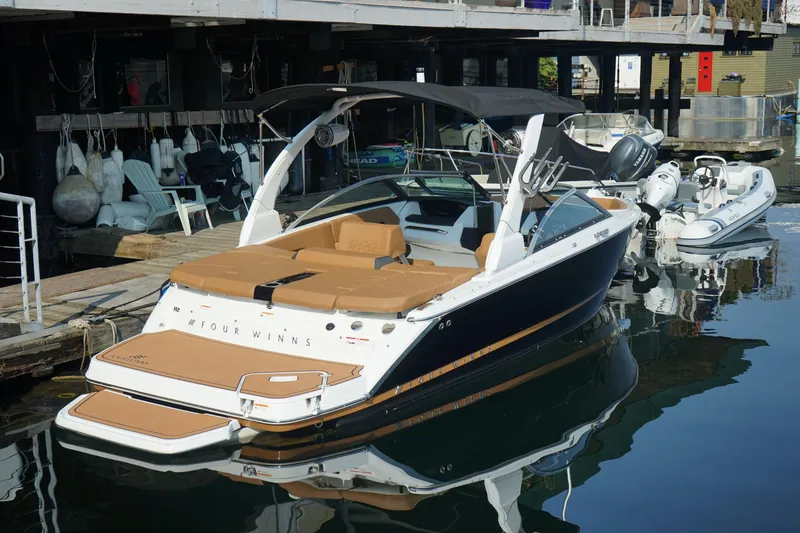 Slide: The Image of 2023 Four Winns H2 Surf boat docked at a marina, featuring sleek design and modern amenities. - 5