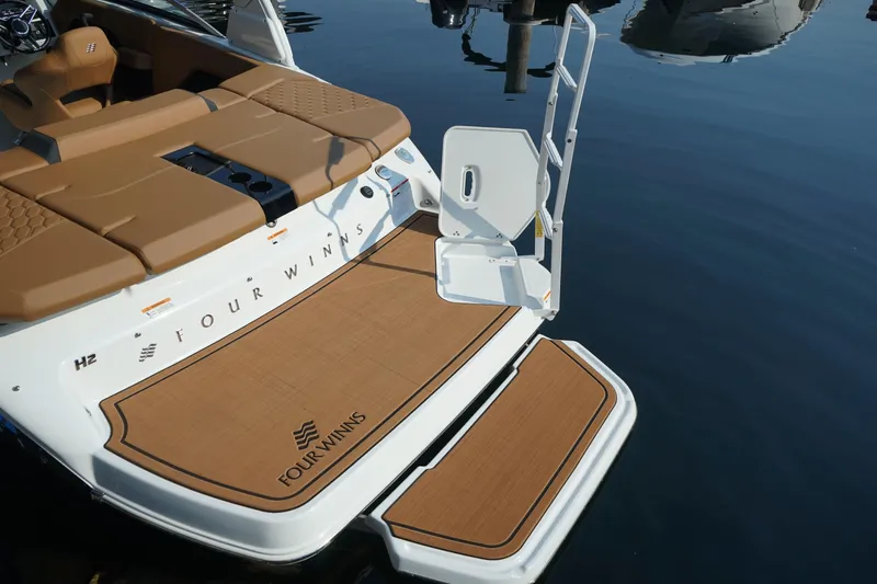 Slide: The Image of 2023 Four Winns H2 Surf boat with swim platform and ladder on calm water. - 8