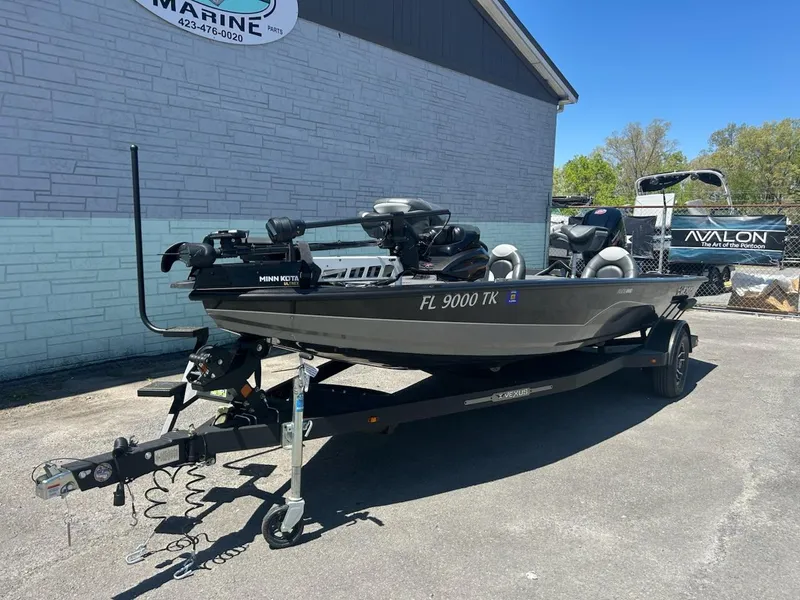 Slide: The Image of 2022 Vexus AVX1880 boat on trailer, parked outside a marine dealership. - 2