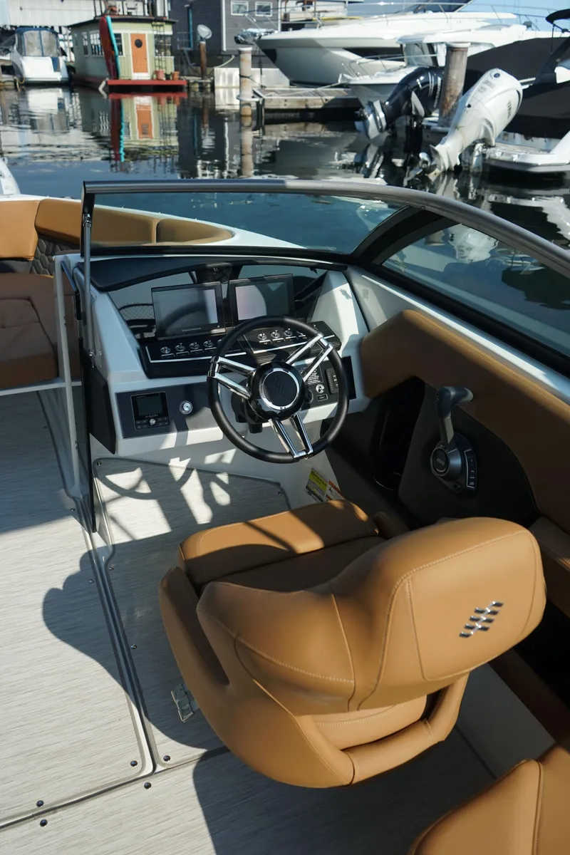 Slide: The Image of 2023 Four Winns H2 Surf boat interior with tan seats and modern dashboard. - 15