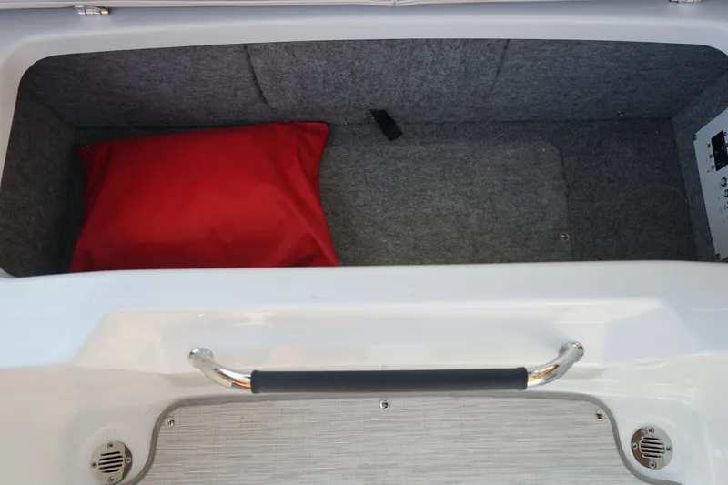 Slide: The Image of Storage compartment of 2023 Four Winns H2 Surf boat with red cushion. - 21