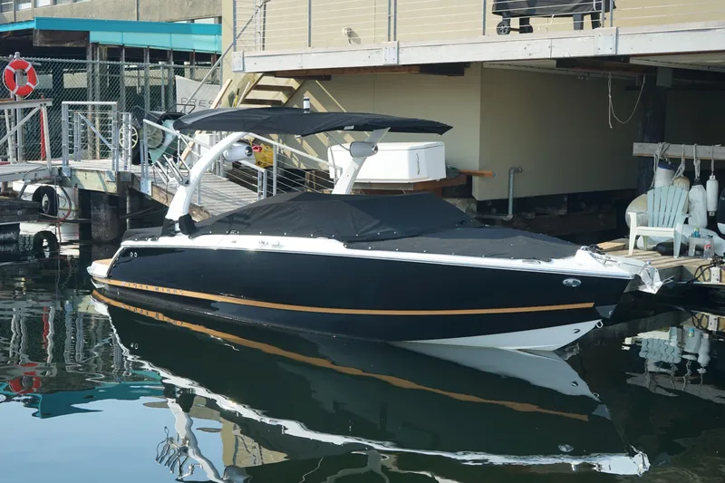 Slide: The Image of 2023 Four Winns H2 Surf boat docked, featuring sleek black design and modern amenities. - 3