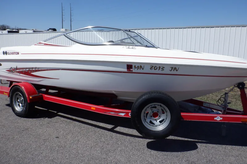 Slide: The Image of 2003 Glastron SX 195 boat on red trailer, parked outdoors. - 1