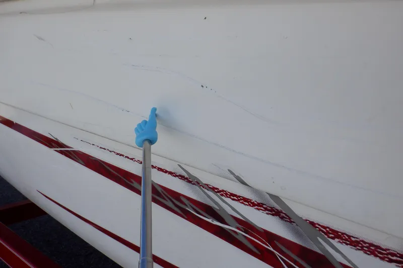 Slide: The Image of 2003 Glastron SX 195 boat with visible hull scratches and red graphics. - 12