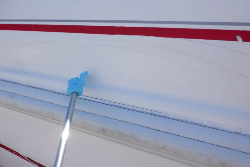 Slide: The Image of 2003 Glastron SX 195 boat with visible scratches on the white hull. - 13