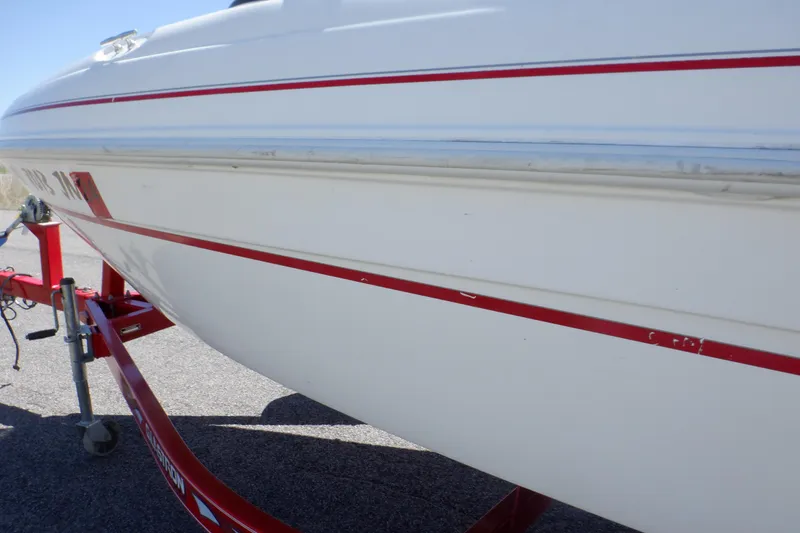 Slide: The Image of 2003 Glastron SX 195 boat on red trailer, side view with red stripe detailing. - 14